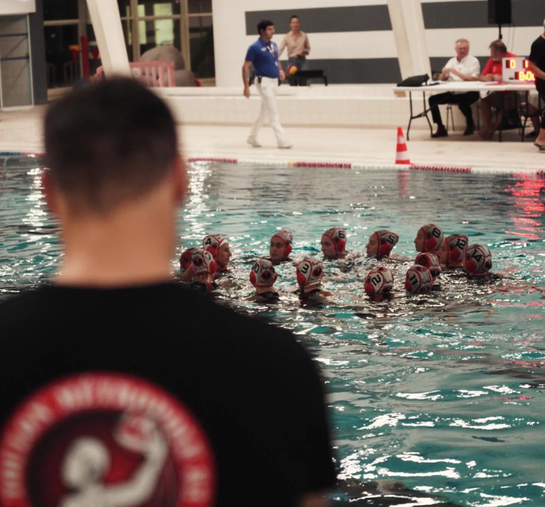 Coach et joueuses de l'équipe Élite au bord du bassin