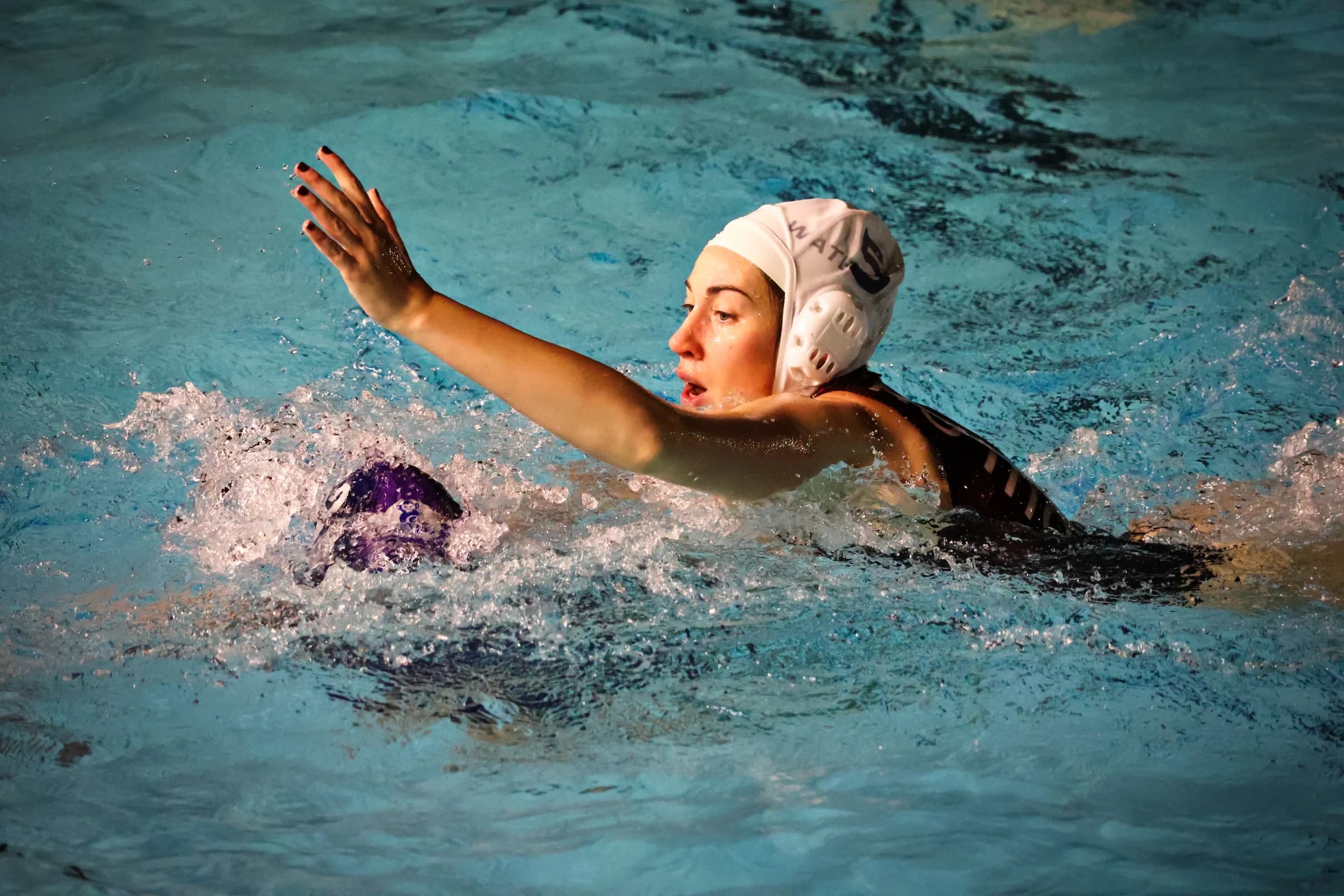 Duel entre deux joueuses de water-polo autour du ballon
